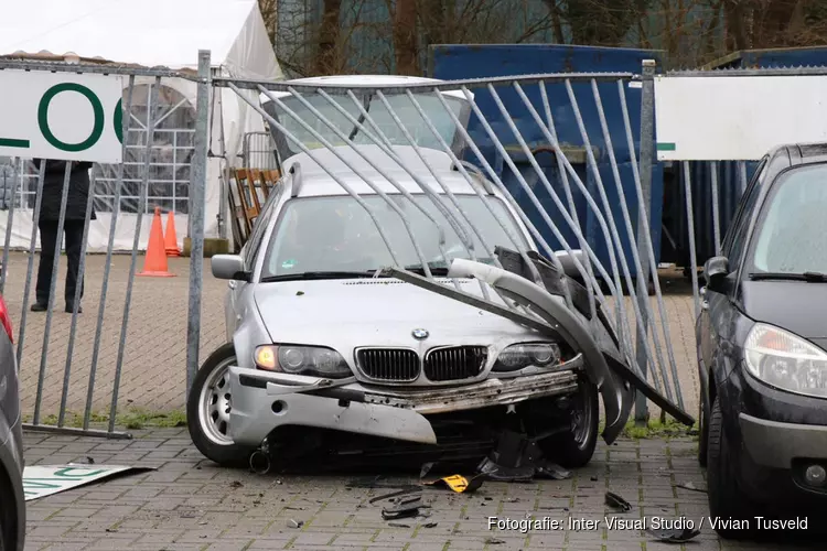Auto door hek bij kringloopwinkel