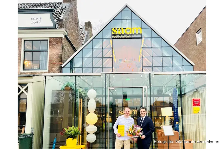 Wethouder Adam Elzakalai feliciteert Bjorn van Aalst van restaurant SAAM met de prijs Gault&Millau Gastheer van het Jaar 2026